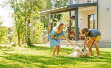 Kids playing with their dog on a weed free lawn